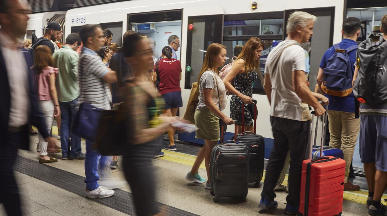 Un andén de Metro abarrotado de gente que entra y sale del tren