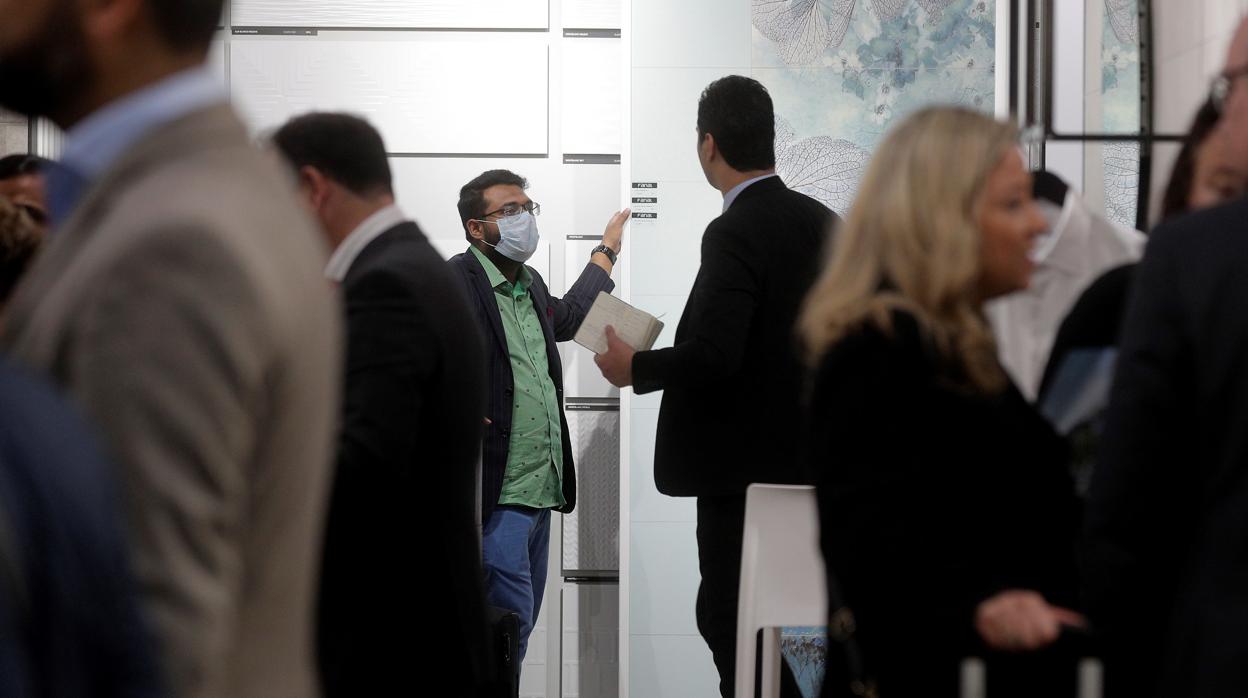 Imagen de una persona con mascarilla recorriendo un stand en la feria Cevisama en Valencia