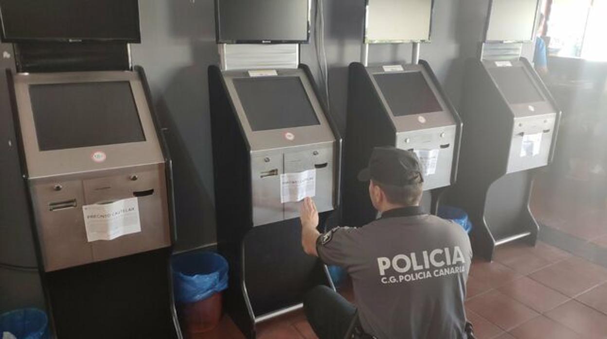 Un agente de la Policía Canaria precinta una de las máquinas