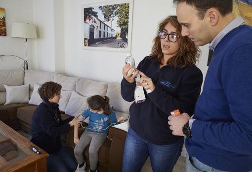 La pediatra atiende a la niña Carmen, que recibe ya el alta, mientras la enfermera da indicaciones a su padre sobre la medicación