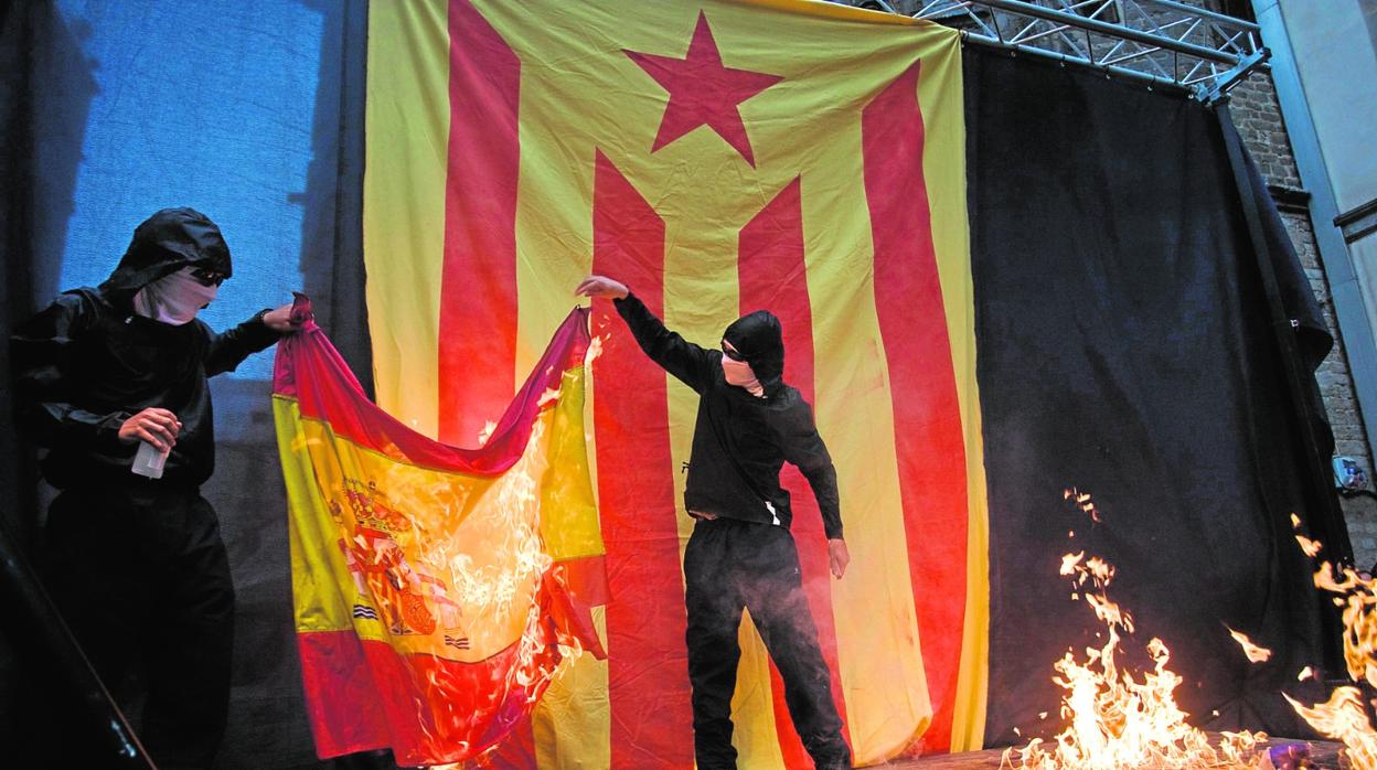 11.09.2011 - Encapuchados queman la bandera de España (antes habían hecho lo mismo con la de Francia) e imágenes (entre ellas la del Rey Juan Carlos I) al acabar la manifestación independentista de la Diada