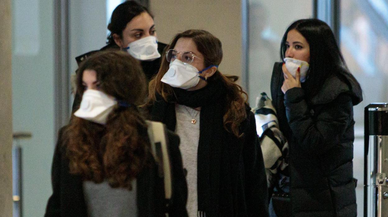 Viajeras procedentes de Italia protegidas con mascarillas a su llegada al aeropuerto de Manises