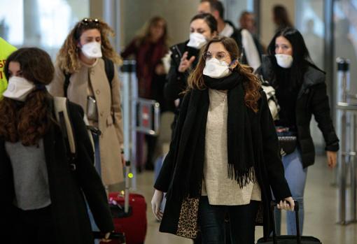 Imagen de viajeros procedentes de Italia protegidos con mascarillas a su llegada al aeropuerto de Manises (Valencia)