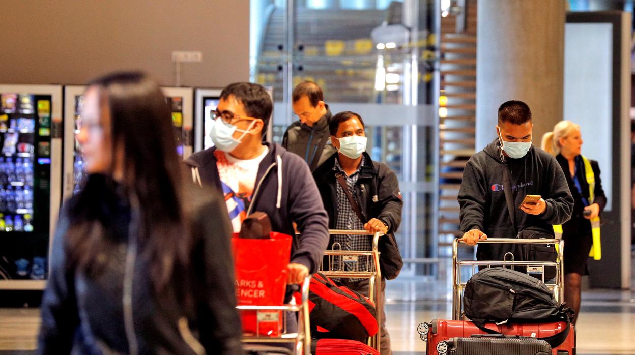 Imagen de varias peraonas con mascarillas en el aeropuerto de Valencia