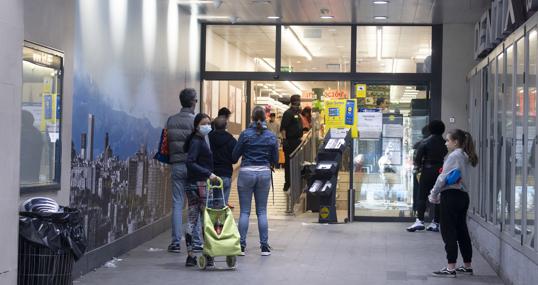 Ciudadanos guardan la fila a un metro de distancia en un supermercado