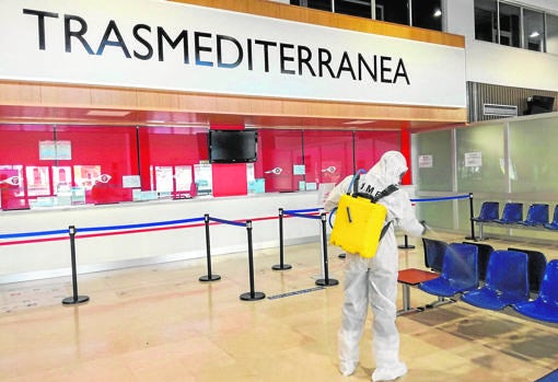 Un militar de la Unidad Militar de Emergencias desinfecta la terminal del puerto de Málaga