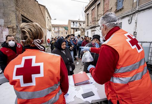 Imagen de voluntarios de la Cruz Roja repartiendo alimentos y kits de higiene en un asentamiento rumano en Valencia como parte de las medidas que se han intensificado a raíz de la crisis del coronavirus