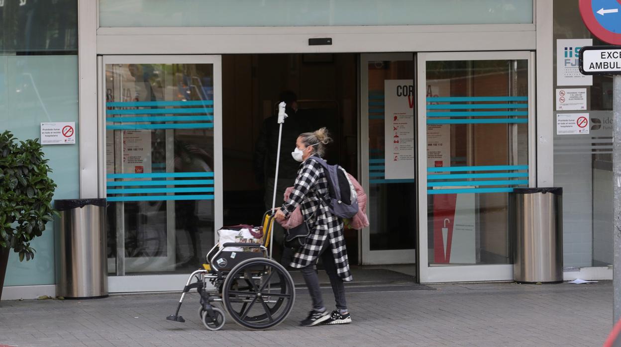 Una mujer con mascarilla pasea por los alrededores del Hospital Fundación Jiménez Díaz