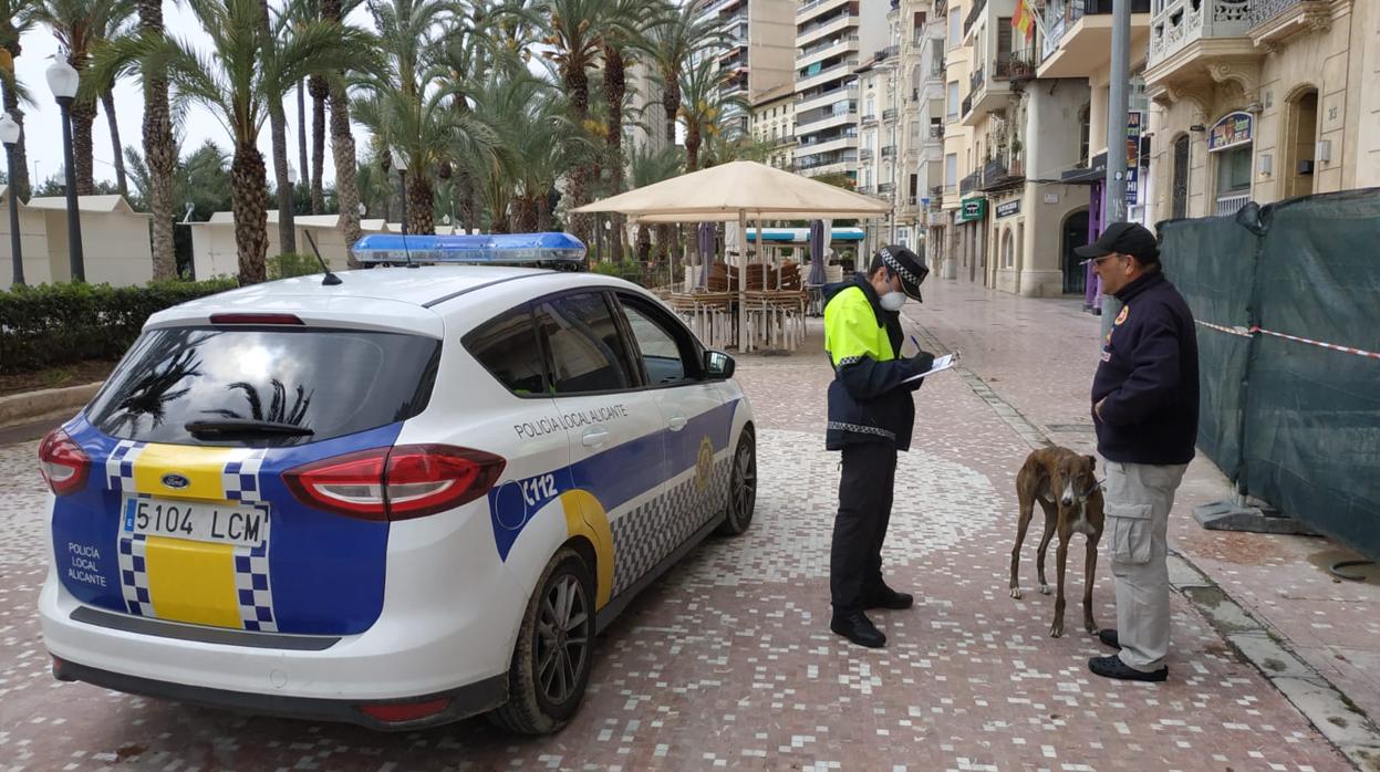 Un agente de la Policía Local de Alicante verificando si el dueño de un perro cumplía con el confinamiento