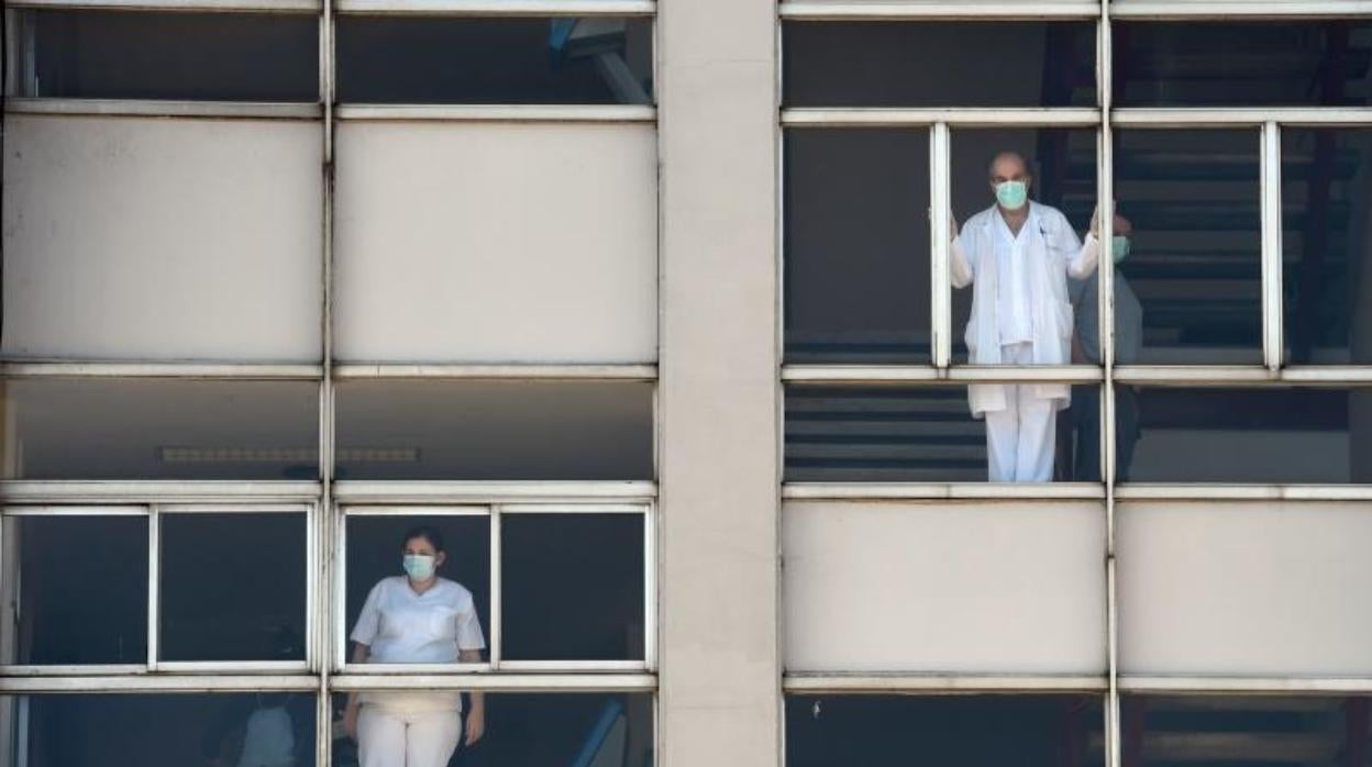 Trabajadores sanitarios miran a través de las ventanas del Hospital Universitario de A Coruña