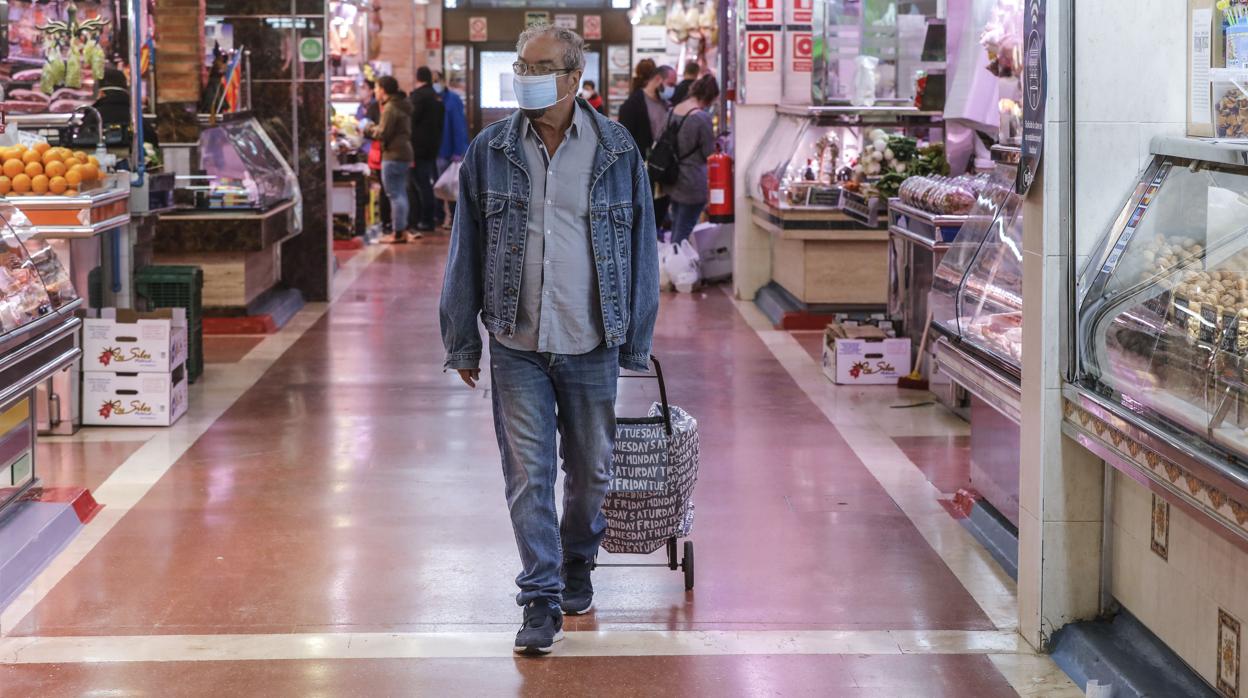 Imagen de un hombre paseando por un mercado en Valencia