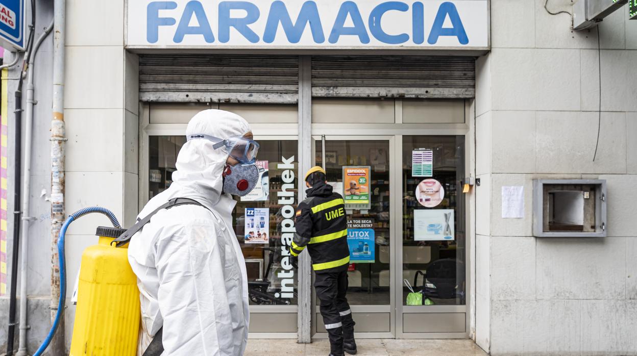 Imagen de los miembros de la UME desinfectando la entrada de una farmacia en Valencia