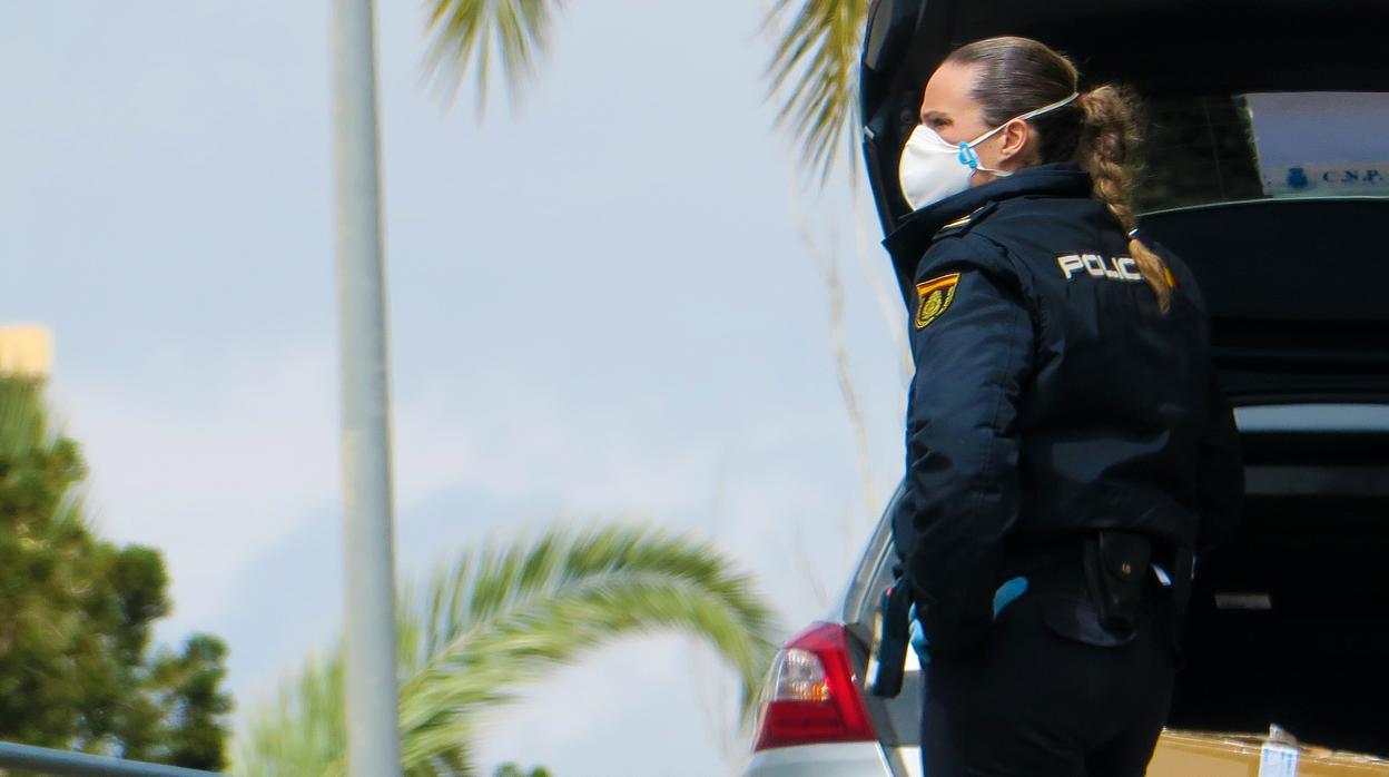 Imagen de una agente de la Policía Nacional con mascarilla por el coronavirus