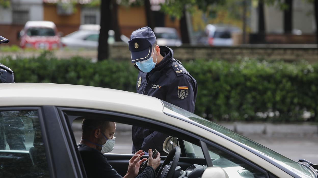 Un policía identifica a un conductor en Sevilla protegido con mascarillas para protegerse del coronavirus