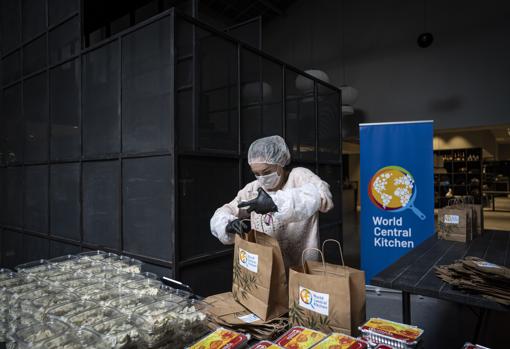 Una mujer del equipo prepara las bolsas con el menú del día