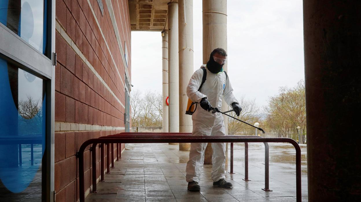 Un operario municipal desinfecta el exterior del pabellón Las Comas donde se ha instalado un hospital de campaña, en Igualada (Barcelona)