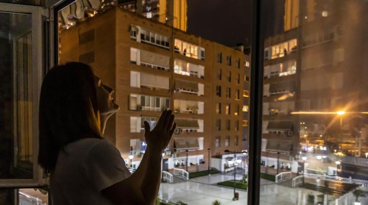 Una mujer participa en los aplaudos colectivos durante el confinamiento en Alicante