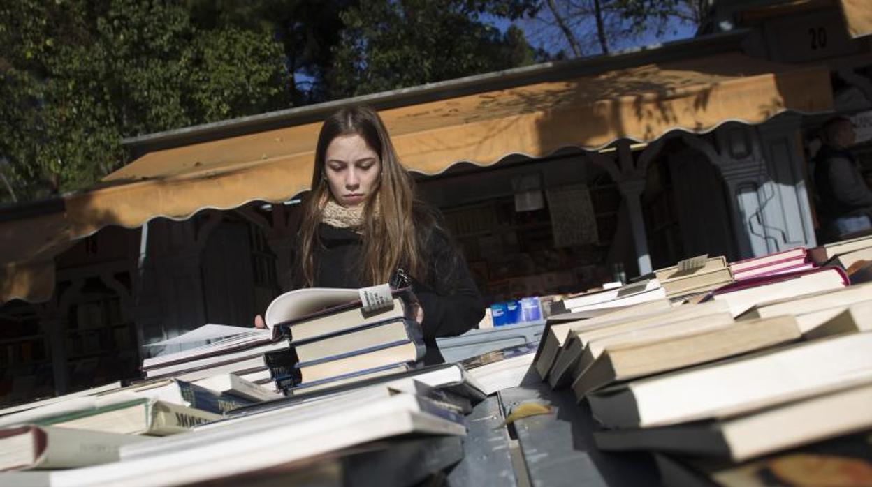 Una joven revisa los libros expuestos en uno de los puestos de la Cuesta de Moyano