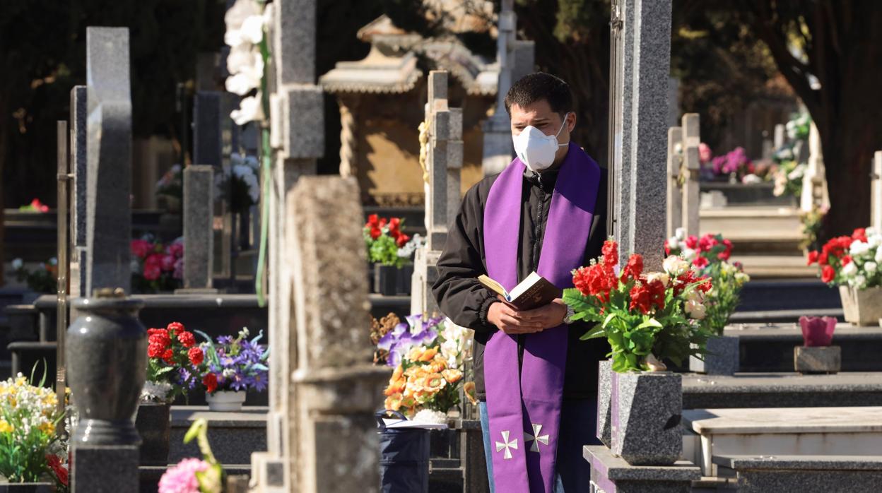 Un sacerdote hace un responso durante un entierro, sin asistentes, en el Cementerio de Salamanca