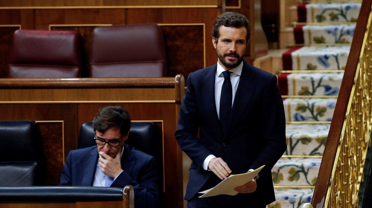 Pablo Casado pasa junto al ministro Salvador Illa, en el Pleno del Congreso