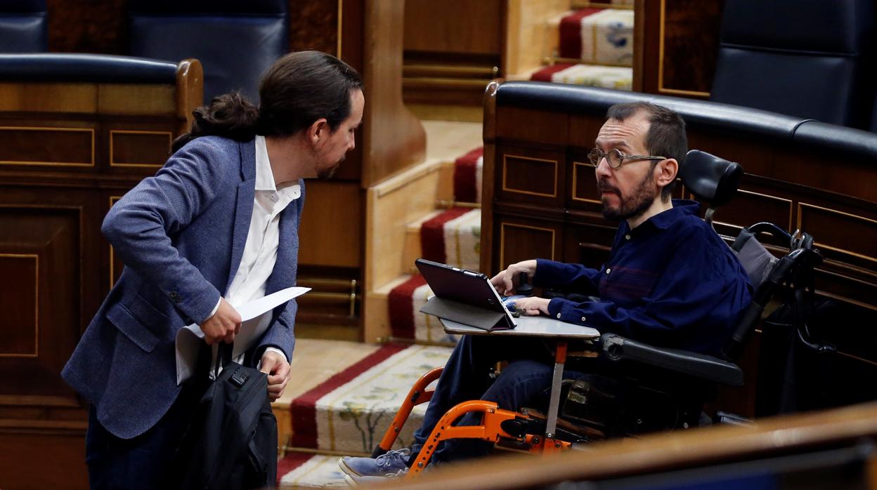 El vicepresidente segundo del Gobierno, Pablo Iglesias (i) conversa con el diputado de Unidas Podemos Pablo Echenique (d) durante el pleno celebrado este jueves en el Congreso