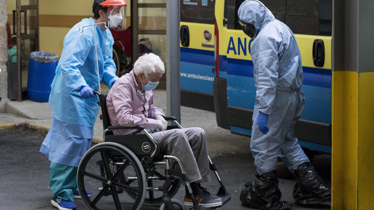 Trabajadores sanitarios trasladan a enfermos por coronavirus al Hospital de Piñor, en Orense, este domingo