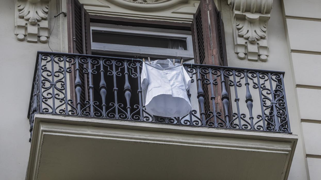 Una bata sanitaria cuelga de un balcón de Valencia