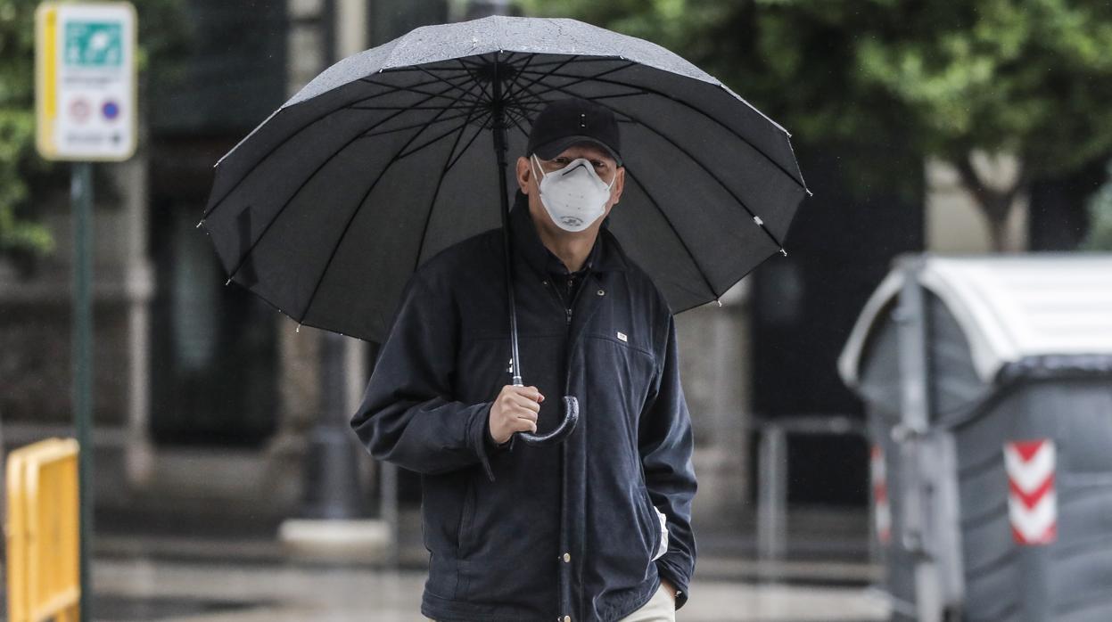 Un hombre se protege con un paraguas en un día de lluvia en Valencia