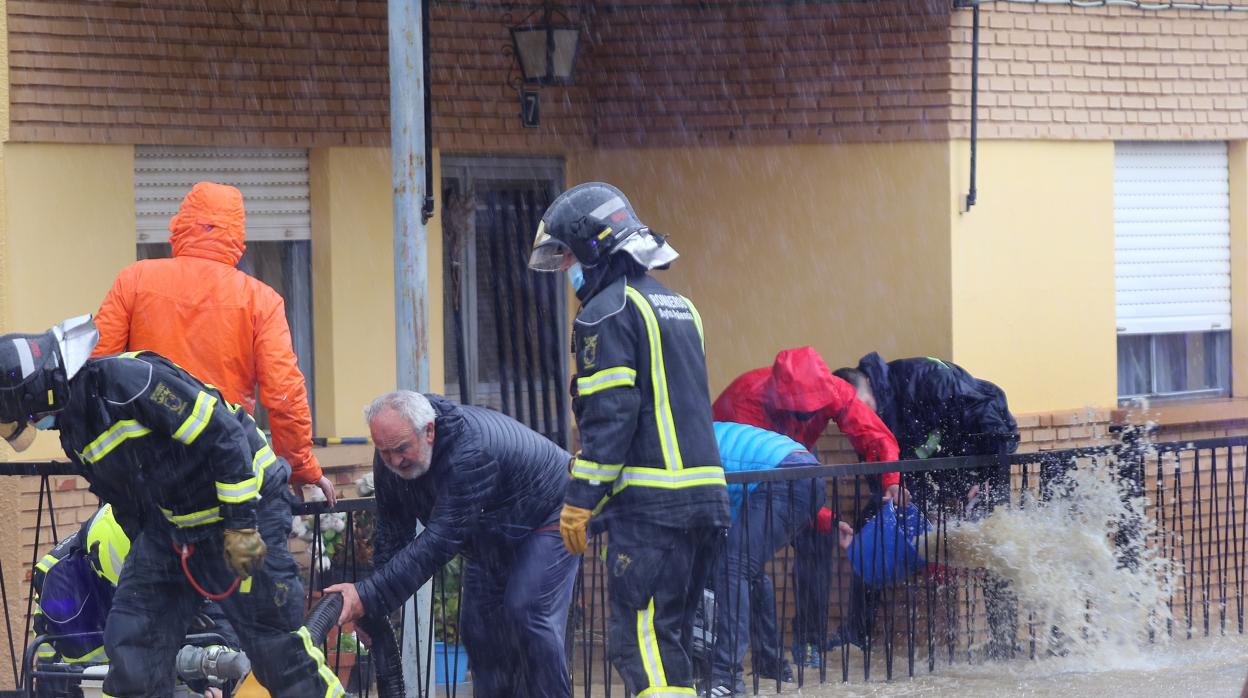 Vecinos y bomberos se afanan en achicar agua en Villamuriel de Cerrato (Palencia)