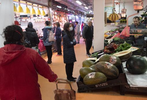 Los compradores se concentran en el último pasillo del mercado de Doña Carlota, en Puente de Vallecas