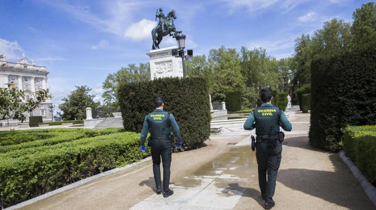 Una pareja de la Guardia Civil patrulla en la plaza de Oriente, bajo la estatua ecuestre de Felipe IV