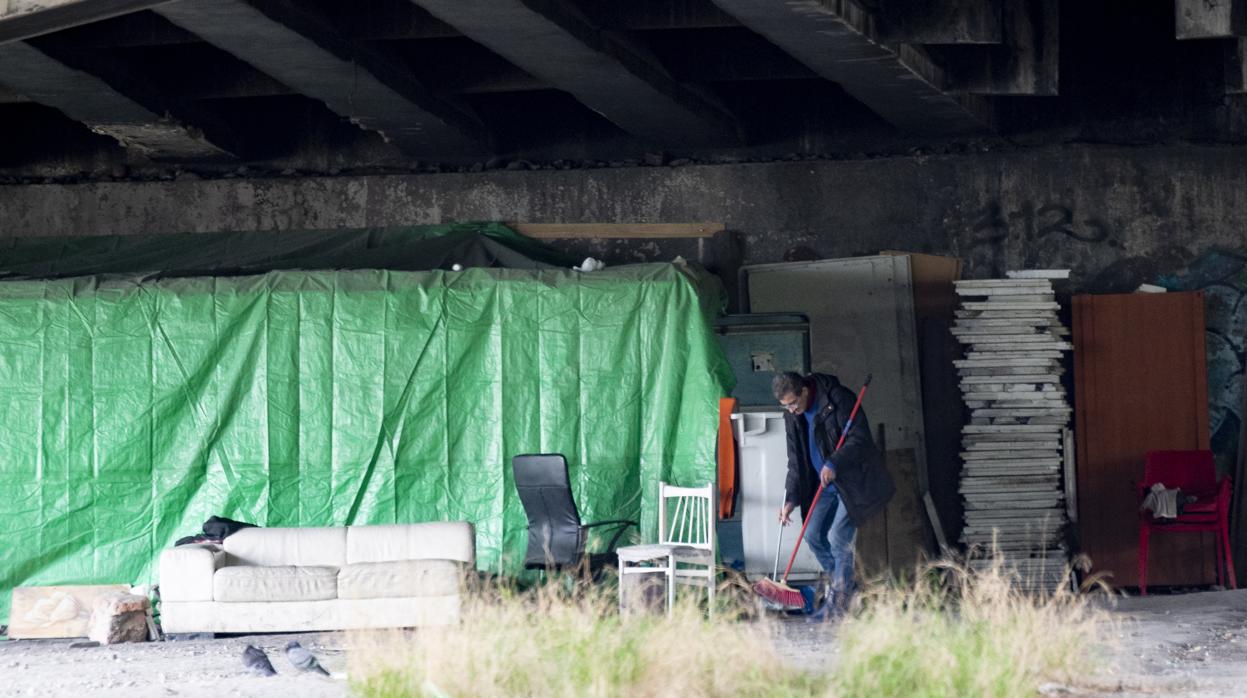 Un toxicómano barre el suelo de una chabola, en Villaverde