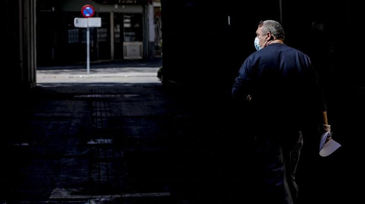 Un hombre camina por una calle vacía en Valencia durante el estado de alarma