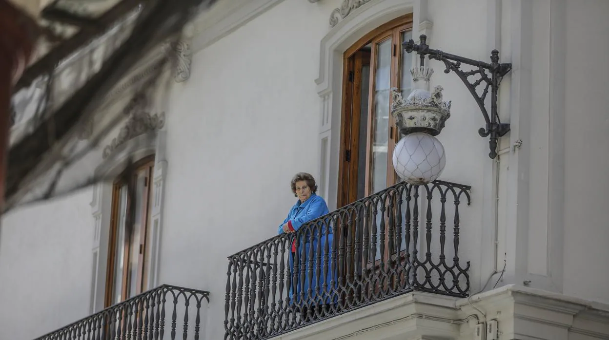 Imagen de una anciana en el balcón de su casa
