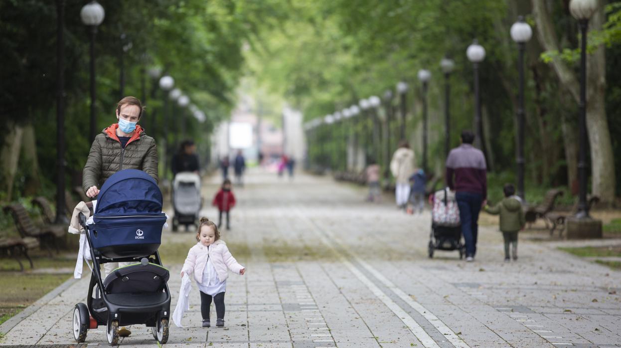 Varias familias por el paseo central del Campo Grande en Valladolid