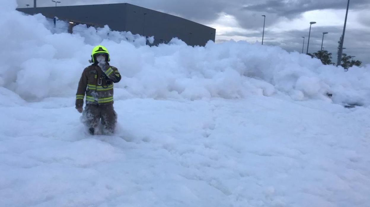 Un bombero avanza entre la enorme cantidad de espuma antiincendios que se ha extendido de forma desconotrolada por una zona de la Plataforma Logística de Zaragoza