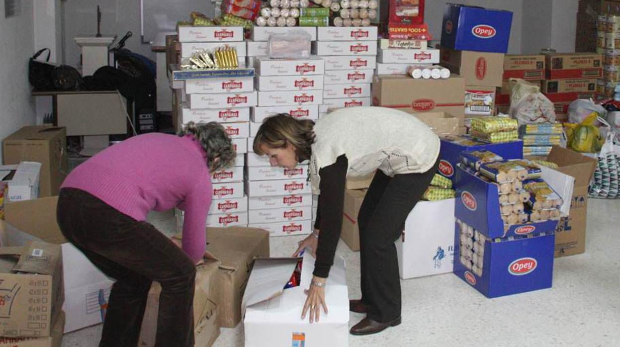 Voluntarias de Cáritas organizan alimenntos en una parroquia