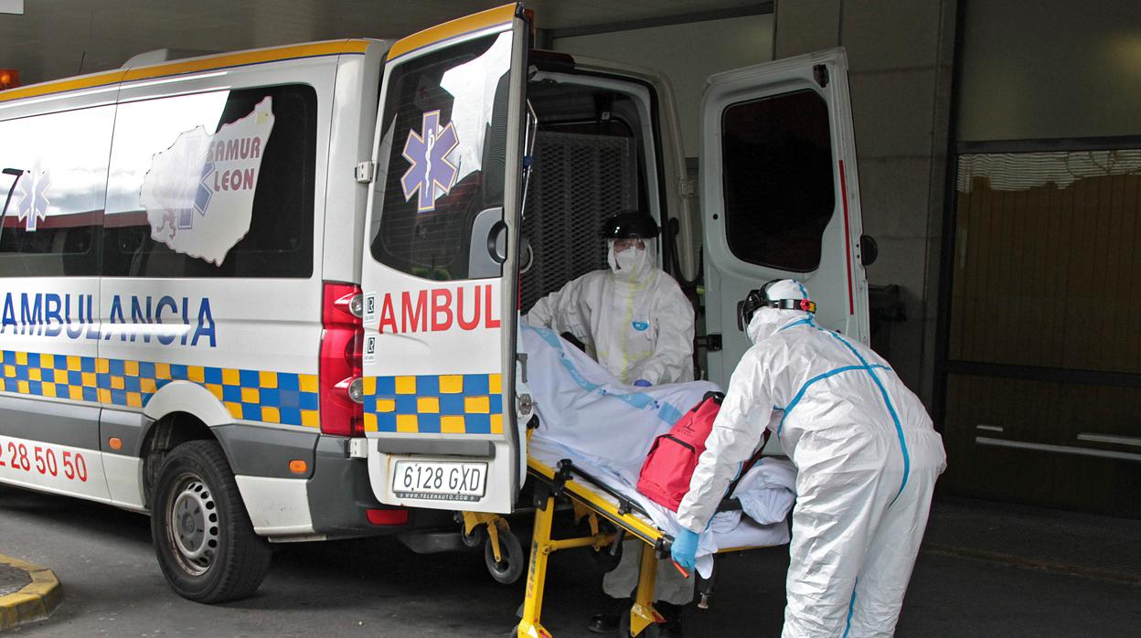 Dos trabajadores trsaladan a un paciente en el Hospital de León