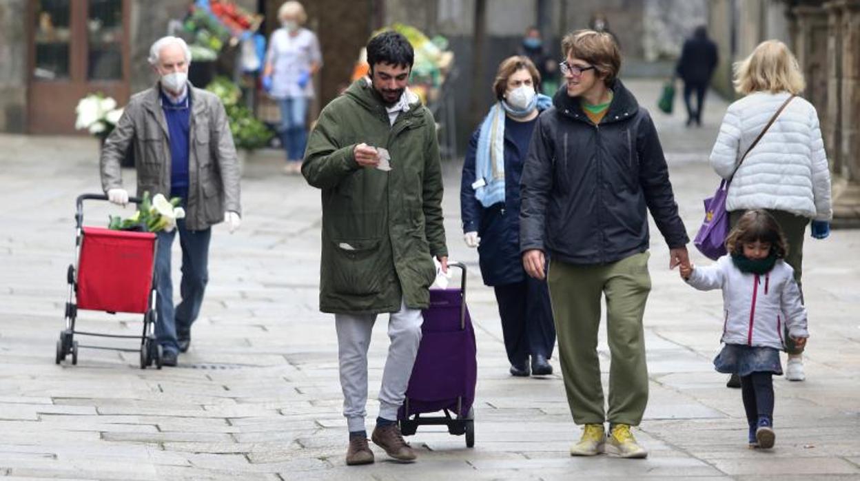 Una familia pasea por una calle de Santiago durante el confinamiento por el coronavirus