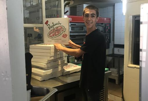 Ángel prepara las cajas de pizzas para el reparto a domicilio