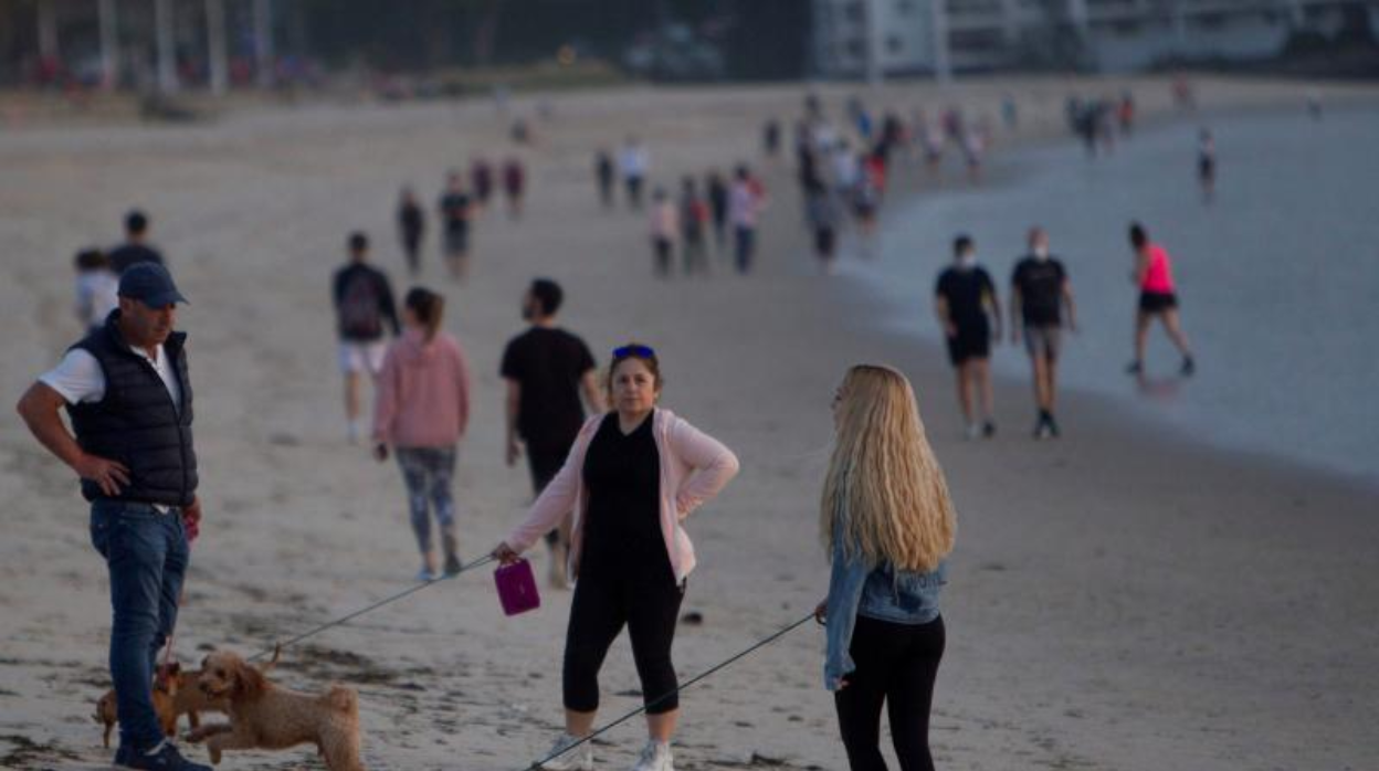 Viandantes por la playa de Samil, en Vigo