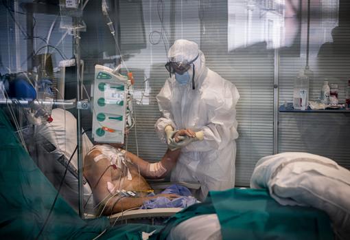 Imagen de un sanitario atendiendo a un paciente con Covid-19 en el hospital Arnau de Vilanova de Valencia