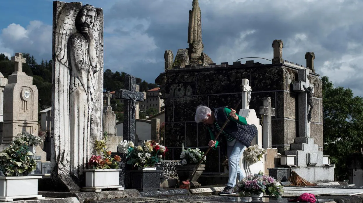 Una mujer realiza labores de limpieza en el cementerio de San Francisco en Orense