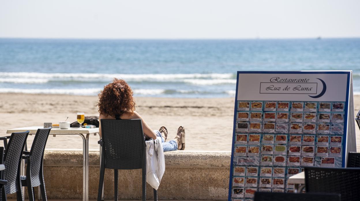 Imagen de una mujer en una terraza de la playa de la Malvarrosa de Valencia