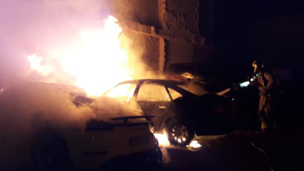 Arden tres coches aparcados en el casco antiguo de Calatayud, entre ellos un Porsche