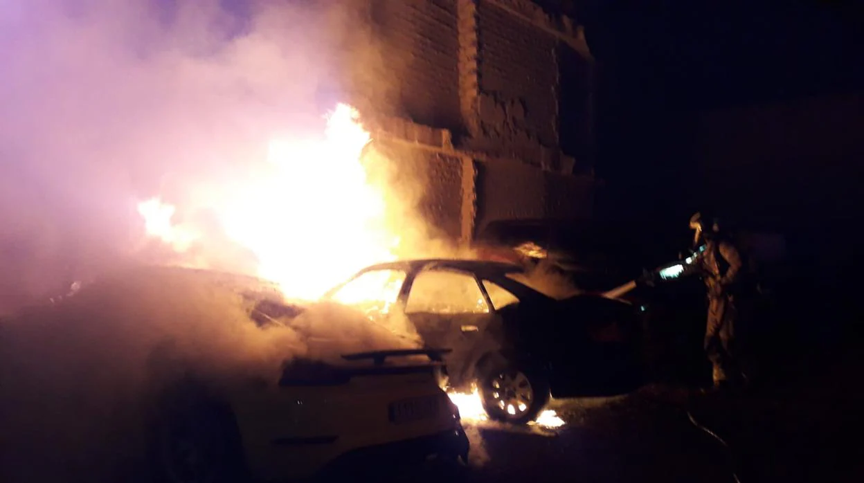 Bomberos ante uno de los vehículos envueltos en llamas en Calatayud