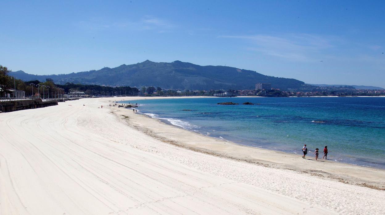 Una familia pasea por la playa de Samil