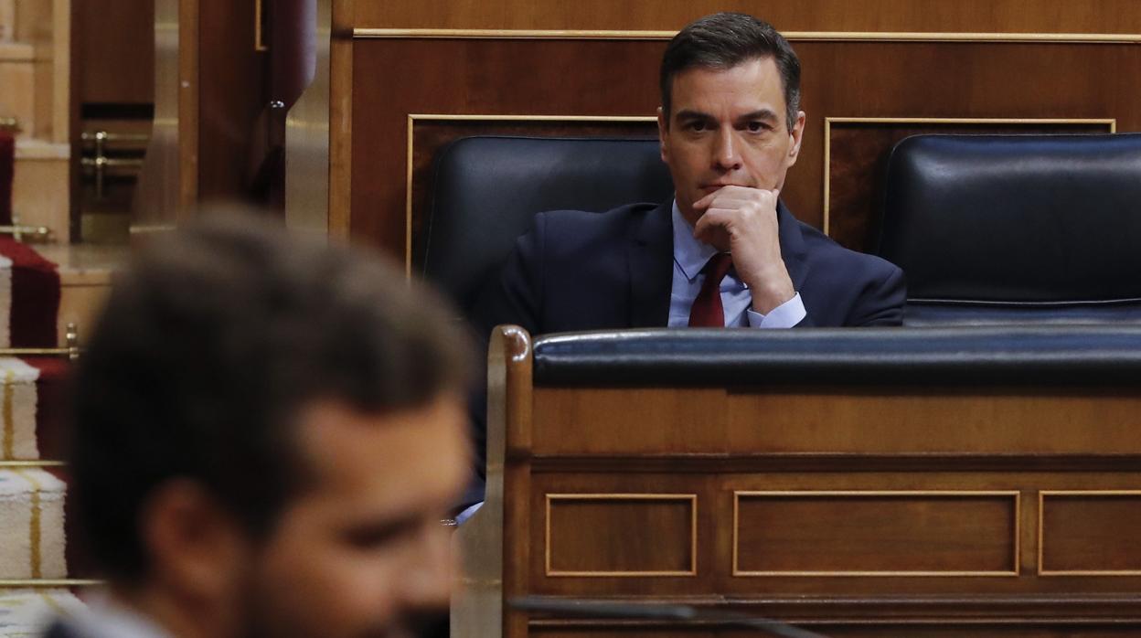 Pedro Sánchez, al fondo, y Pablo Casado, en primer plano, ayer en el Congreso