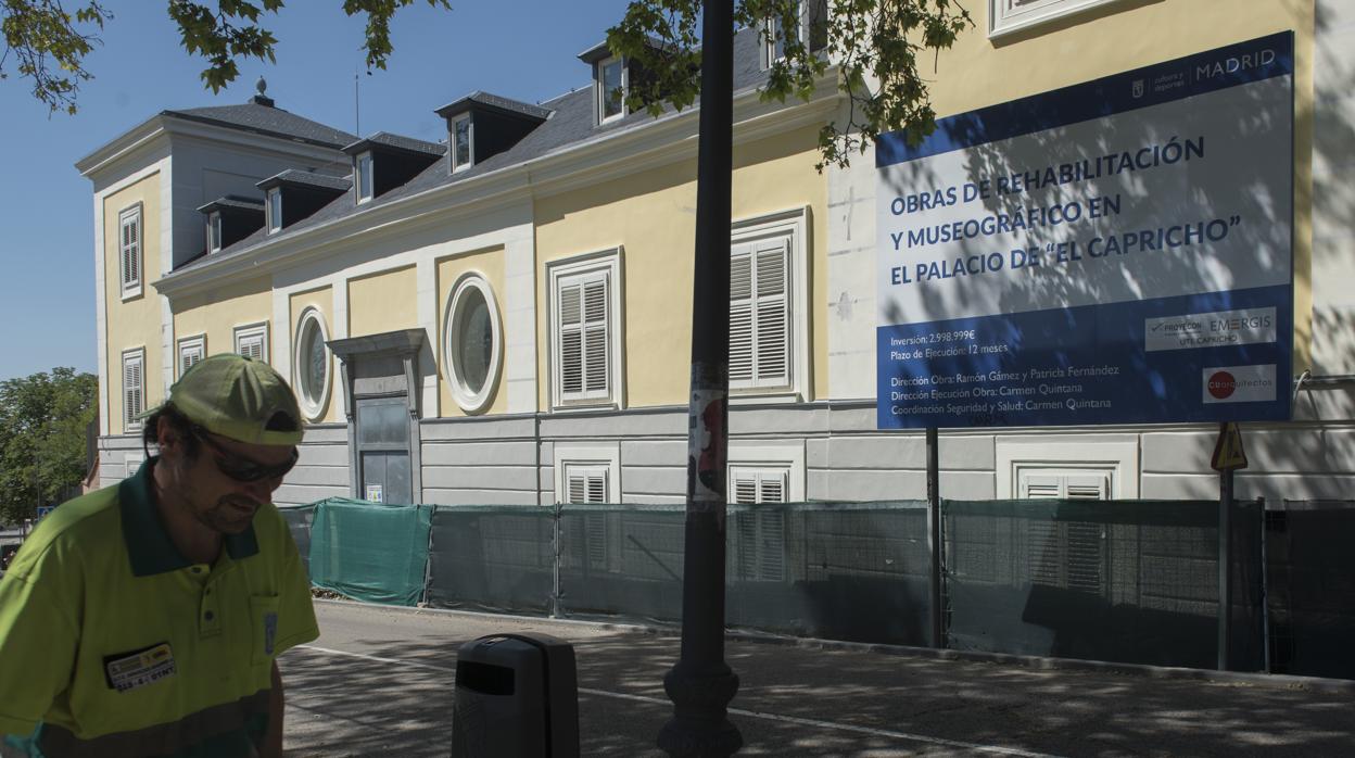 Un operario pasa ante el cartel que anuncia las obras de musealización del palacio del parque de El Capricho