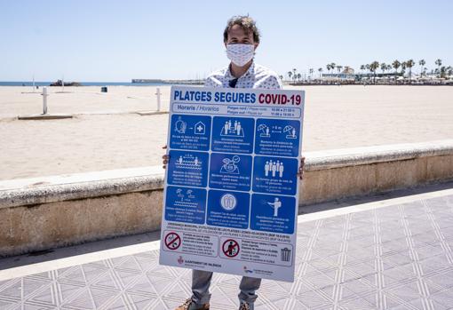 Imagen del edil Grezzi con uno de los carteles informativos para las playas